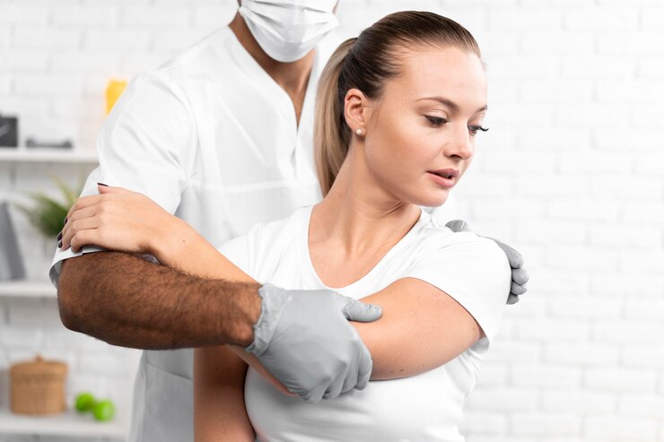 male physiotherapist checking woman s shoulder 23 2148780728